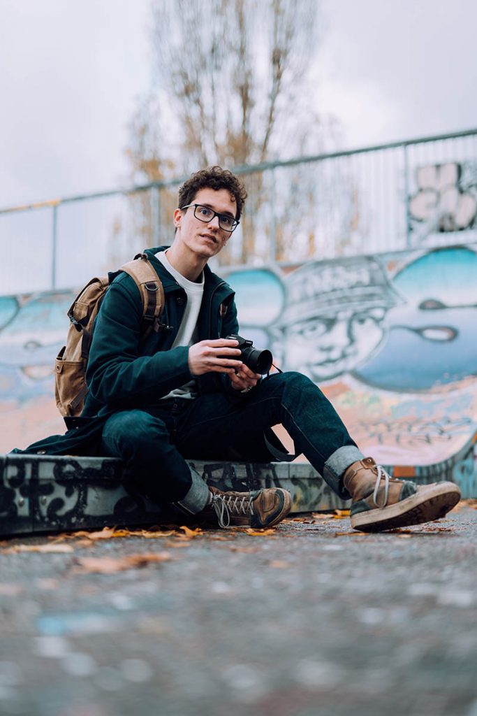 Photographe assis devant un mur peint
