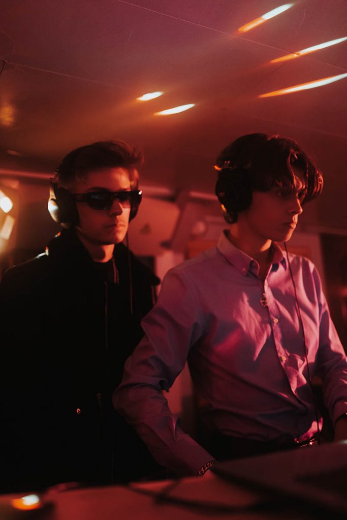 Deux DJs concentrés dans une lumière rouge