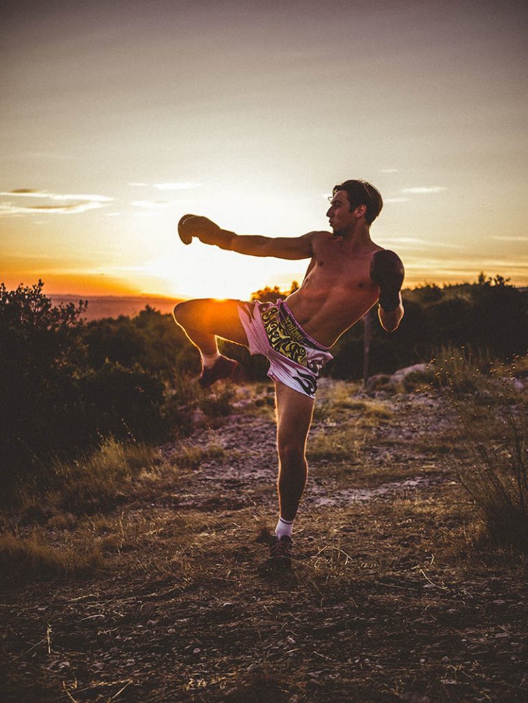 Coup de pied de boxe thaï au coucher du soleil