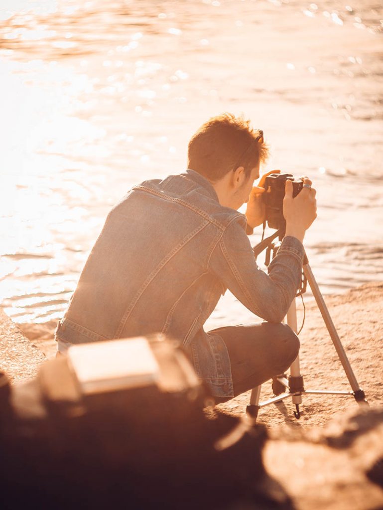 Photographe sur trépied face au soleil