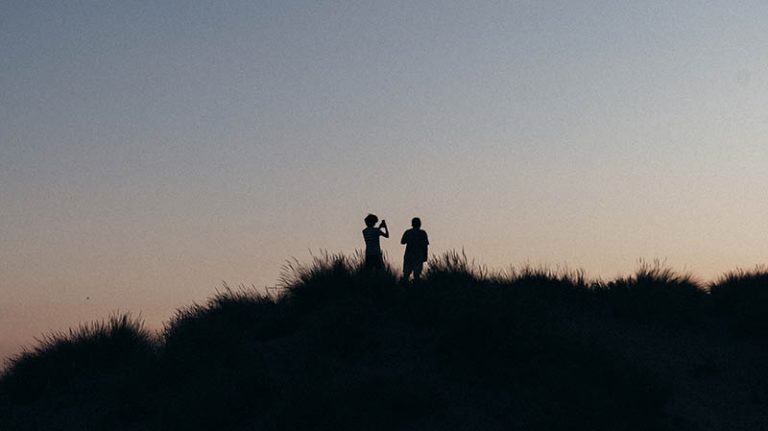Silhouettes sur une dune à la golden hour