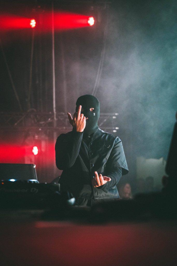 DJ cagoulé sous des lumières rouges
