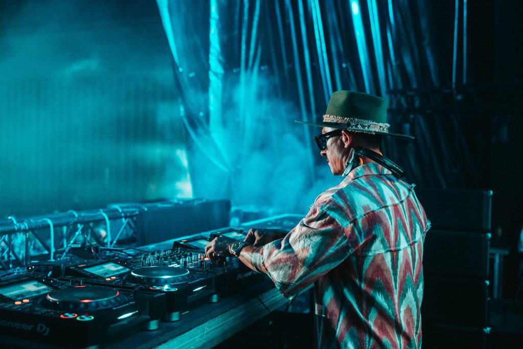 DJ aux platines, scène éclairée en turquoise