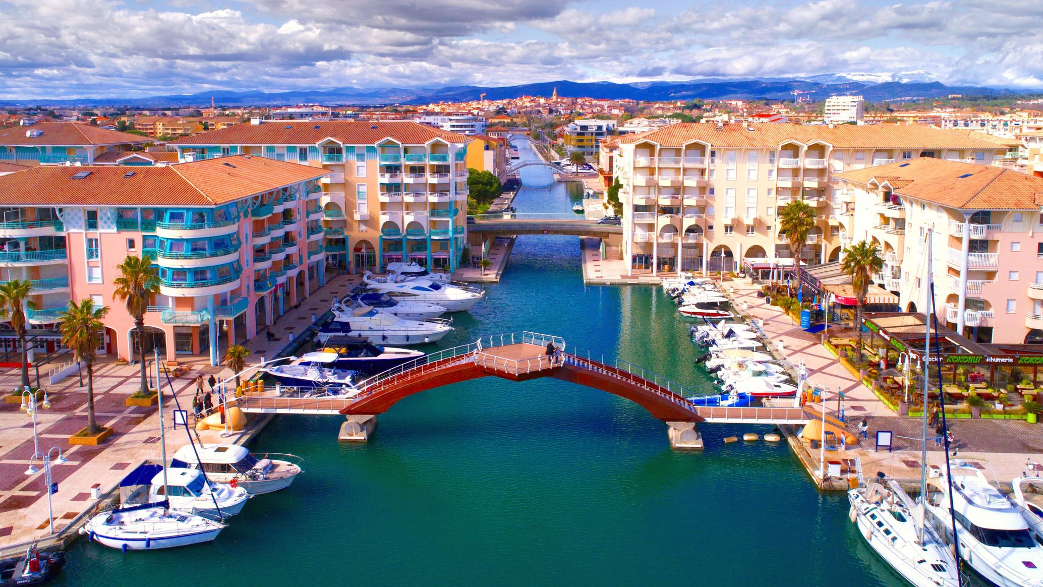 Le port de Fréjus, ses façades colorées et sa passerelle rouge, vus du ciel