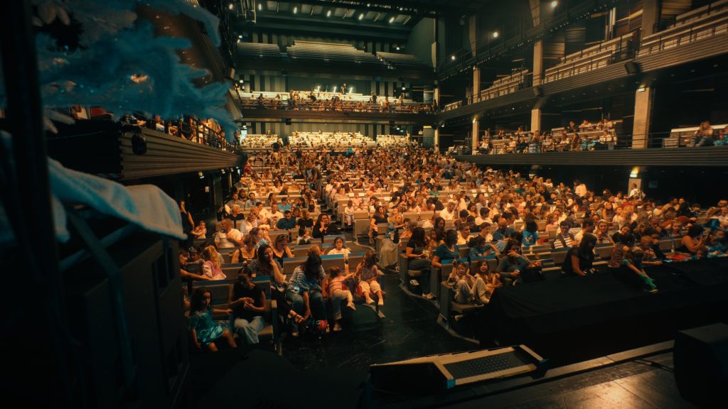 View from the stage of the auditorium filled with spectators