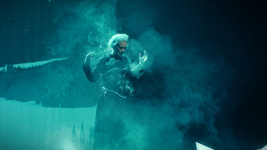 A costumed character wrapped in icy mist on stage
