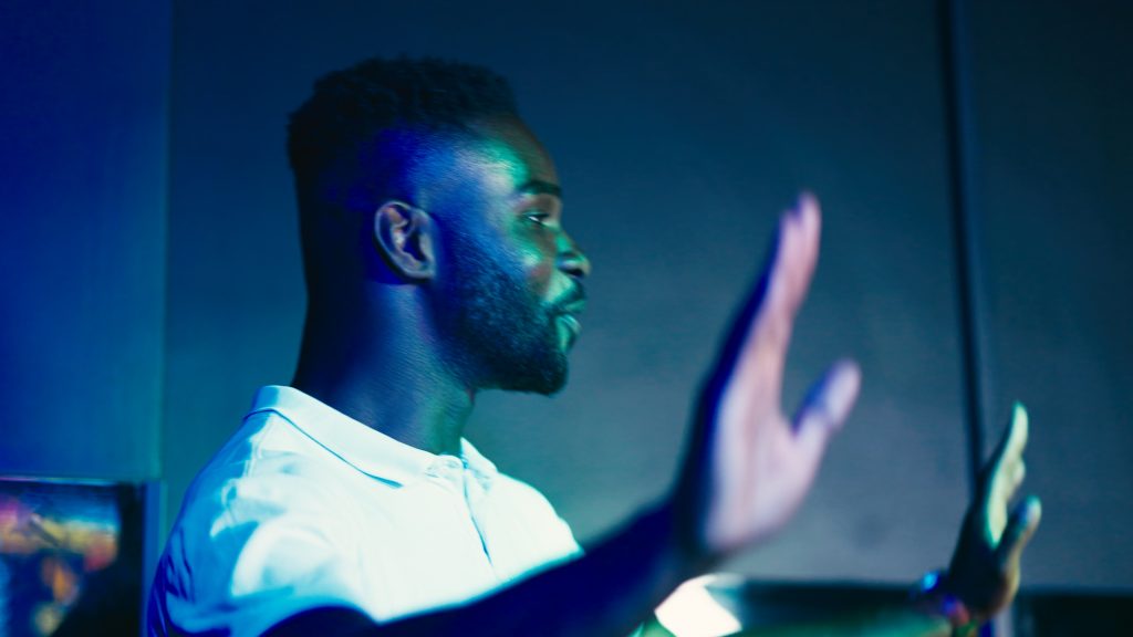 A player with a raised hand, in blue light
