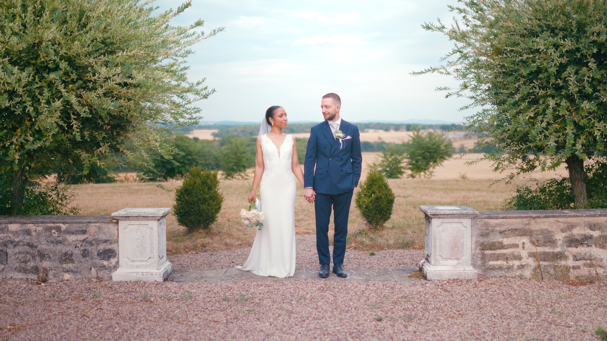 Angélique and Dorian hand in hand in the garden of Domaine de Mont