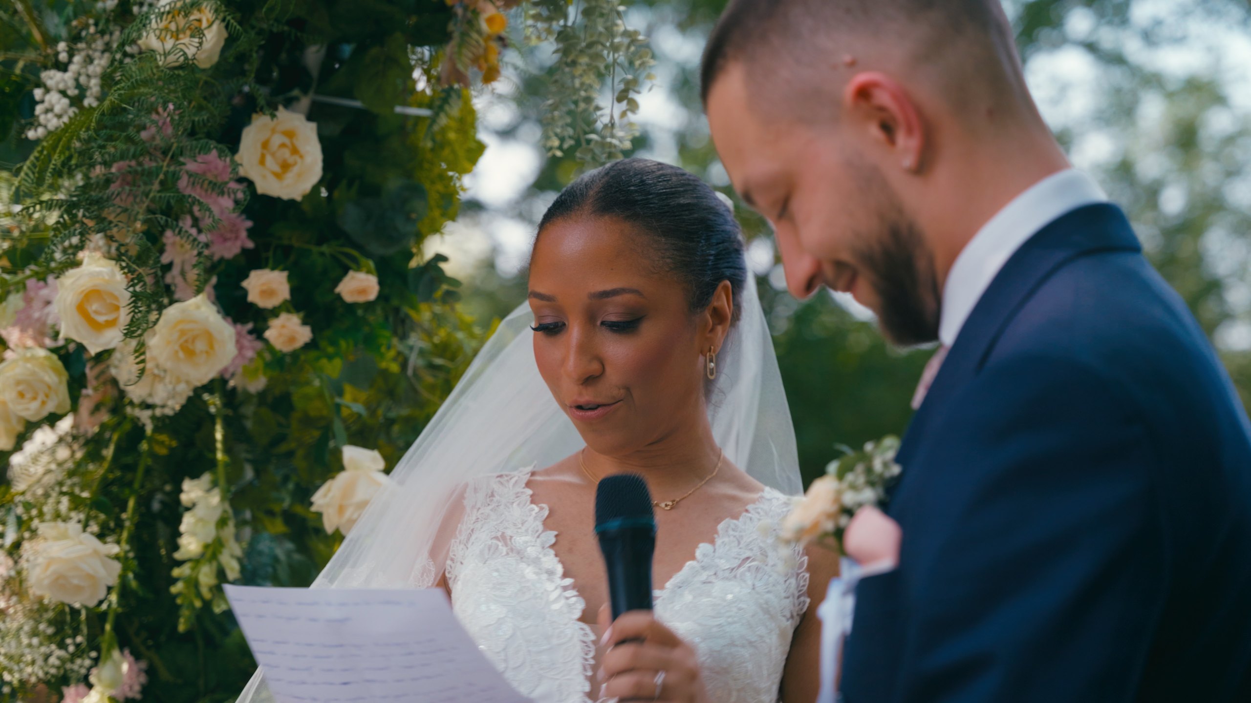 Angélique reading her vows to Dorian under the floral arch